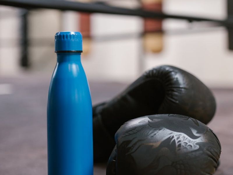 Close up of sports equipment and water bottle on floor